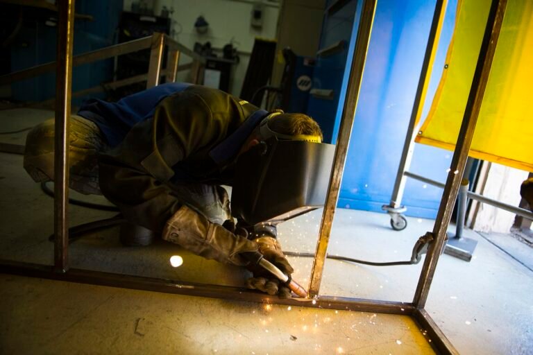 Welder laying a bead on a steel frame with sparks flying